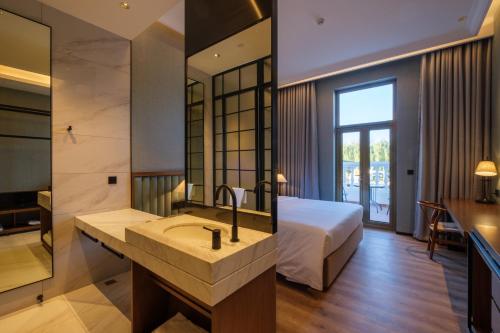 a bathroom with a sink and a bed in a room at Moon River Puyue Hotel in Beijing