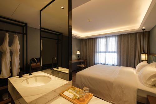 a hotel room with a bed and a sink at Moon River Puyue Hotel in Beijing