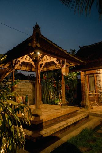 a wooden gazebo with stairs in front of a house at Kapten Nyoman House in Saba