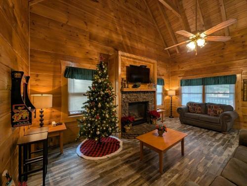 a living room with a christmas tree in a cabin at ER206 - Mountain Rendezvous Great location - Close to town! cabin in Pigeon Forge