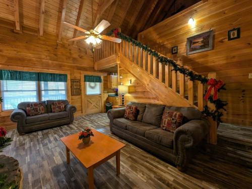 a living room with couches and a staircase in a cabin at ER206 - Mountain Rendezvous Great location - Close to town! cabin in Pigeon Forge