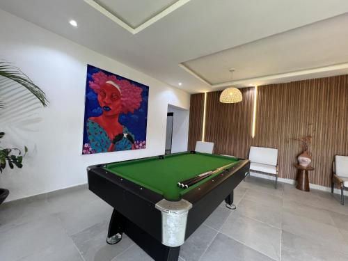 a pool table in a room with a painting at Masque Lagos in Lagos