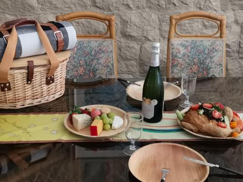 a table with a bottle of wine and a plate of food at Mary MacKillop Spirituality Centre Central Coast in Kincumber South