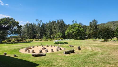 a cemetery with benches in a grass field at Mary MacKillop Spirituality Centre Central Coast in Kincumber South