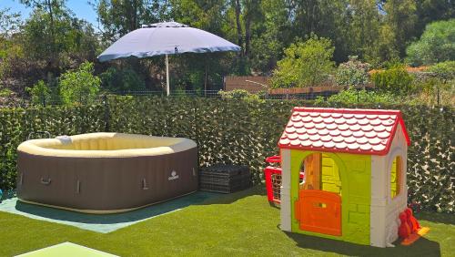 two playhouses and a hot tub in the grass at Serendipity, La Caletta in La Caletta