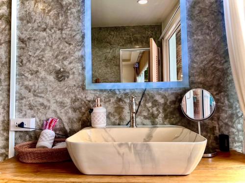 a bathroom with a white tub and a mirror at Bella Lunar Villa ดอยแม่สลอง in Mae Salong