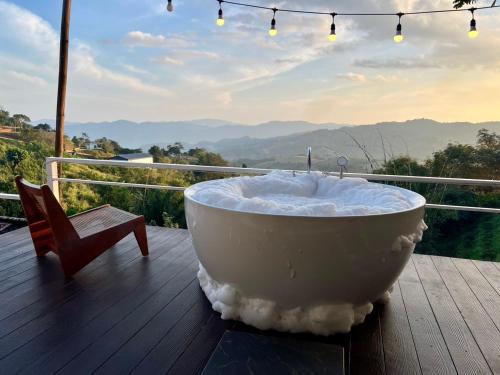 a bath tub sitting on top of a wooden deck at Bella Lunar Villa ดอยแม่สลอง in Mae Salong