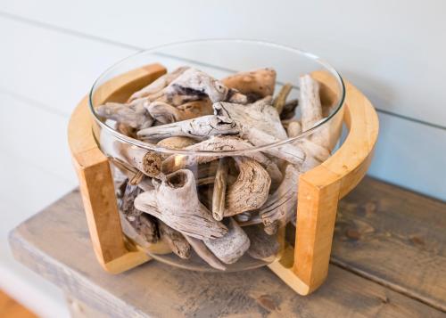 a glass bowl of mushrooms on a wooden stand at The Mooring Ocean Vw 3b Coastal Experience in Topsail