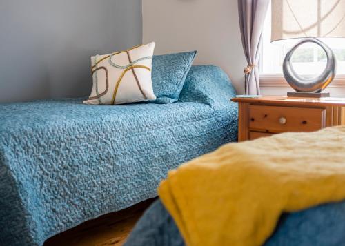 a bedroom with a blue couch with a pillow and a mirror at The Mooring Ocean Vw 3b Coastal Experience in Topsail