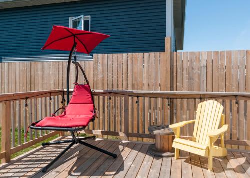 a patio with a red chair and an umbrella at The Mooring Ocean Vw 3b Coastal Experience in Topsail