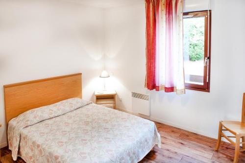 a bedroom with a bed and a window at Résidence Les Marquises in Aspin-en-Lavedan