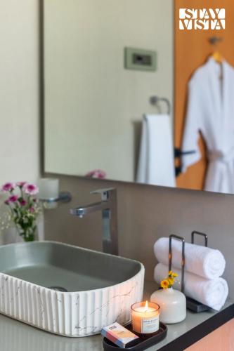 a bathroom with a sink with towels and a mirror at The Den by Vieda - Part of StayVista in Karjat