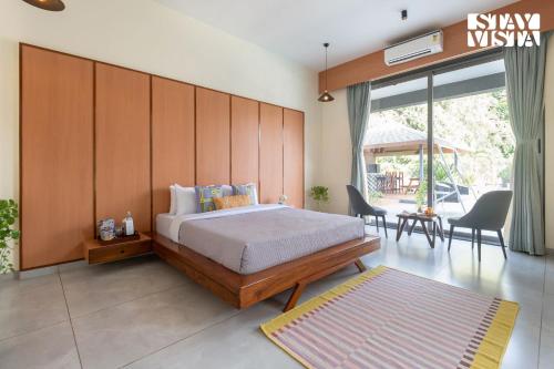 a bedroom with a bed with a wooden wall at The Den by Vieda - Part of StayVista in Karjat
