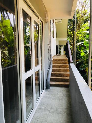 a porch of a house with glass doors at Devon Surf . Inn - Hiriketiya in Dickwella