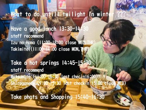 a woman eating food with chopsticks in a bowl at Yamagata Guesthouse山形ゲストハウス in Murayama