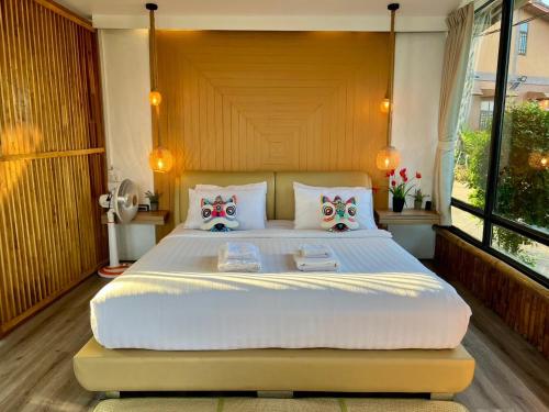 a bedroom with a large white bed with a large window at Bella Lunar Villa ดอยแม่สลอง in Mae Salong