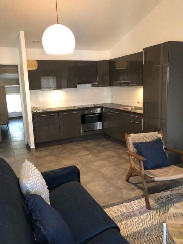 un salon avec un canapé et une cuisine dans l'établissement Bel appartement bord de mer, à Sainte-Maxime