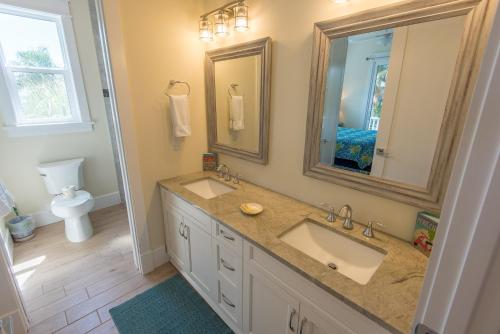 ein Badezimmer mit zwei Waschbecken, einem Spiegel und einem WC in der Unterkunft Coastal Horizons in Bradenton Beach