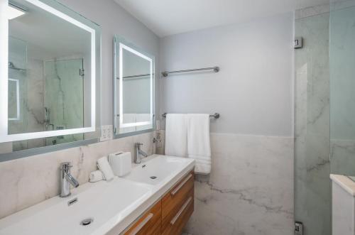 a white bathroom with a sink and a shower at Ocean Dreamin in Encinitas