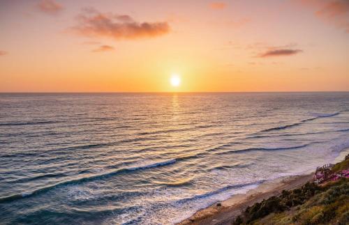 a sunset over the ocean with the sun setting at Ocean Dreamin in Encinitas
