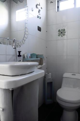 a white bathroom with a sink and a toilet at Estudio Los Mosaicos in Vicuña