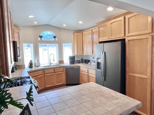 a kitchen with wooden cabinets and a stainless steel refrigerator at The Joshua Tree House in Joshua Tree