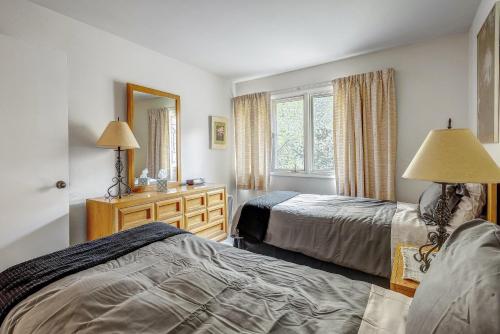 a bedroom with two beds and a mirror at Peaceful creek view from the deck! Walk to Shuttle in Vail