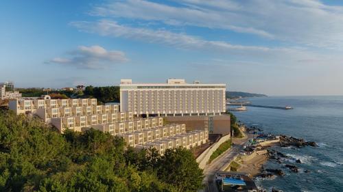 an aerial view of a large building next to the water at PANAQ operated by SONO in Yeongdeok
