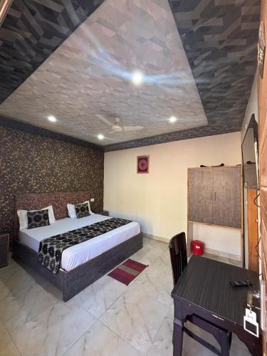 a bedroom with a bed and a table in it at Baakhli Guest House and Restaurant in Bhowāli