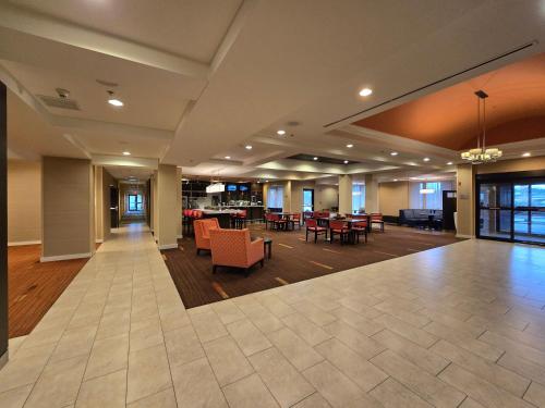an empty lobby with tables and chairs in a building at Country Inn & Suites by Radisson, Convention Center in Altoona