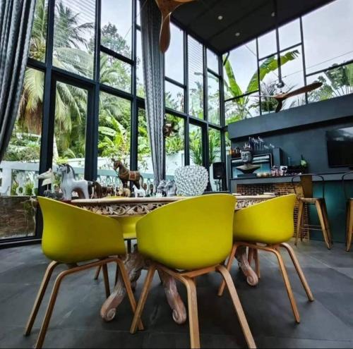 a dining room with yellow chairs and a table at O - HO Boutique Home in Baan Tai