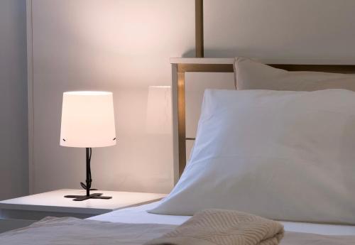 a bed with a white pillow and a lamp at The Title Residencies Naiyang by EIE ASIA in Phuket