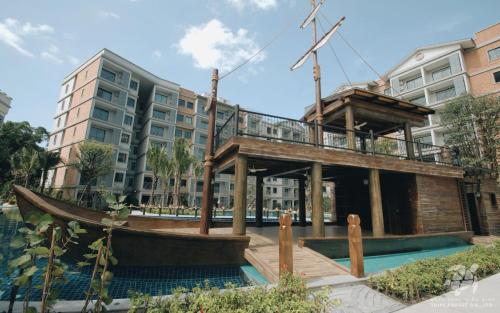 a building with a boat in front of a building at The Title Residencies Naiyang by EIE ASIA in Phuket