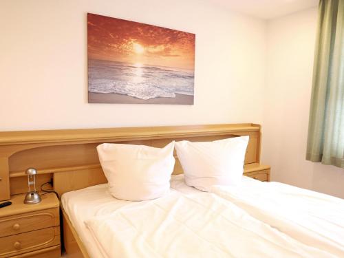a bedroom with a bed with white sheets at Das geräumige 2-Zimmer-Appartement in Westerland (Sylt)
