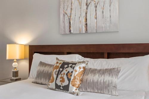 a bedroom with a bed with white sheets and pillows at Relaxing Escape + Large Deck - 12 Min to Red Rocks in Lakewood