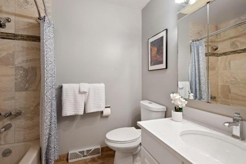 a white bathroom with a toilet and a sink at Relaxing Escape + Large Deck - 12 Min to Red Rocks in Lakewood