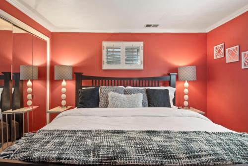 a red bedroom with a bed and two lamps at Relaxing Escape + Large Deck - 12 Min to Red Rocks in Lakewood