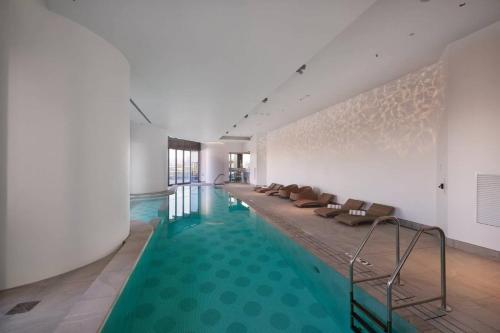 a pool with a row of chairs in a building at Riverfront 2 Bedroom Apt in Brisbane City with Parking in Brisbane