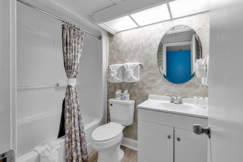 a bathroom with a toilet and a sink and a mirror at Stunning Views Atlantica Towers Condo in Myrtle Beach