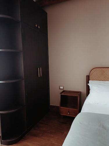 a bedroom with a bed and a black cabinet at A La Maison in Shillong
