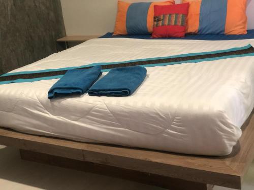 two beds with blue pillows on top of them at Lantacocogarden in Ko Lanta Yai