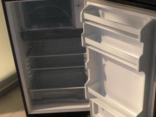 an empty refrigerator with its door open at Lantacocogarden in Ko Lanta Yai