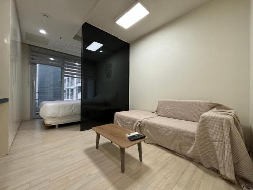 a bedroom with a bed and a coffee table at The Hide City in Jeju