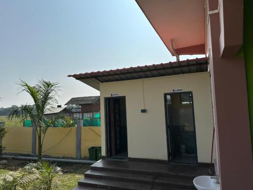 a building with a door and stairs in front of it at Alpine Resort in Sivasagar