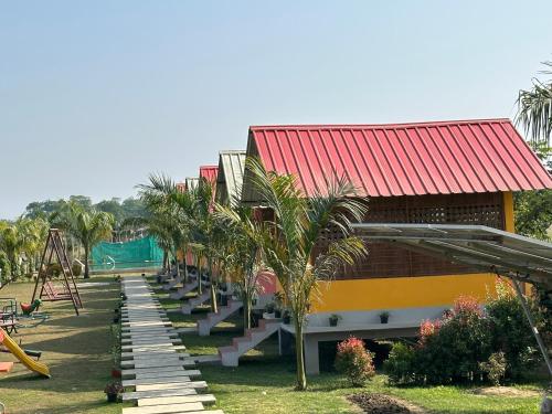 a resort with a playground with palm trees and a slide at Alpine Resort in Sivasagar
