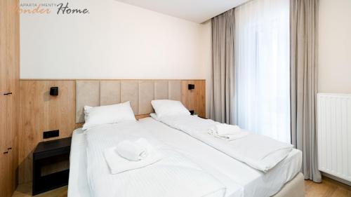 a bedroom with two beds with white sheets at Wonder Home - Domki Hillside tuż przy stoku narciarskim - na terenie kompleksu plac zabaw i zewnętrzna siłownia, sklep, parking in Karpacz