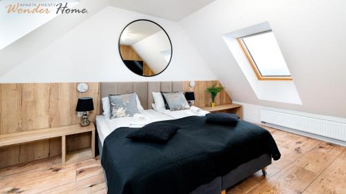 a bedroom with a large bed and a mirror at Wonder Home - Domki Hillside tuż przy stoku narciarskim - na terenie kompleksu plac zabaw i zewnętrzna siłownia, sklep, parking in Karpacz