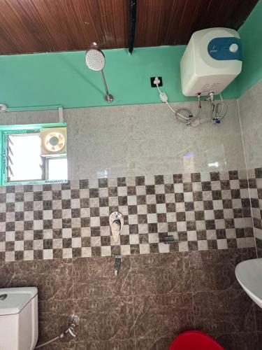 a bathroom with a checkeredkered floor and a toilet at Alpine Resort in Sivasagar