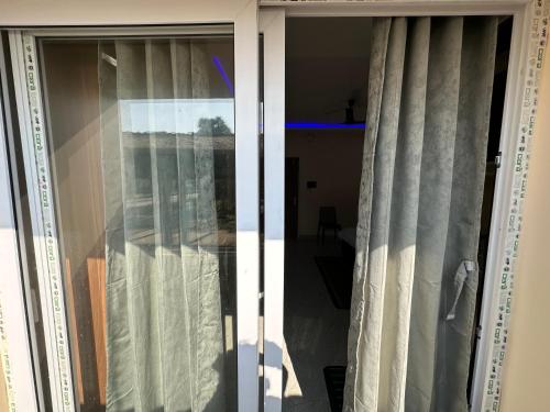 a sliding glass door with curtains in a room at Alpine Resort in Sivasagar