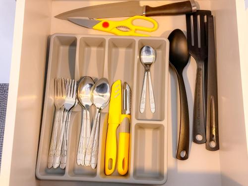 a tray filled with utensils with a yellowknife at The Apple Suites Melaka in Melaka